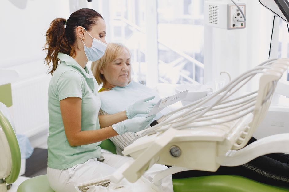 Senior dental patient discussing denture options with her dentist during a consultation